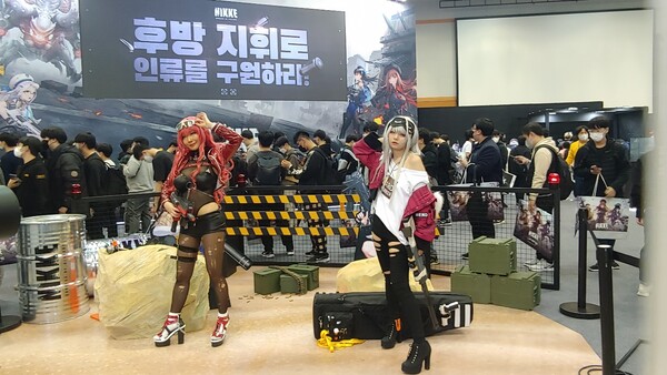 -포즈를 취하는 코스튬 플레이어들과 레벨인피니트 부스 앞에 줄 선 관람객들