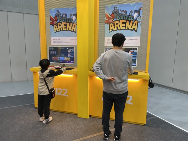 - 아이와 함께 2인용 게임을 즐기는 부모 관람객