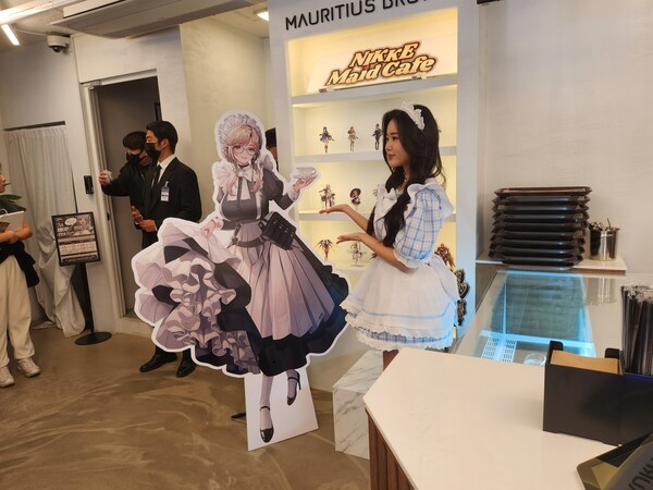 - 계산대 옆에서 등신대와 함께 포즈를 취하는 예쁜 누나